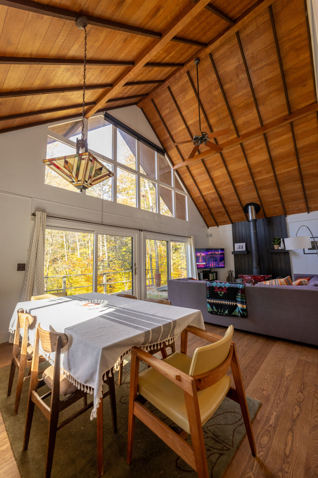 Cathedral dining and living space with a wall of windows